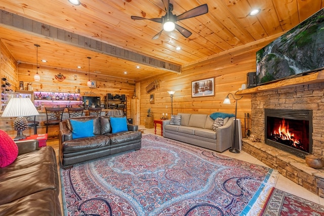 living room featuring wood ceiling, ceiling fan, wood walls, and a fireplace