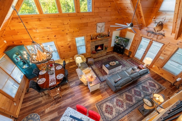 living room featuring a stone fireplace, wooden ceiling, high vaulted ceiling, beam ceiling, and dark hardwood / wood-style floors