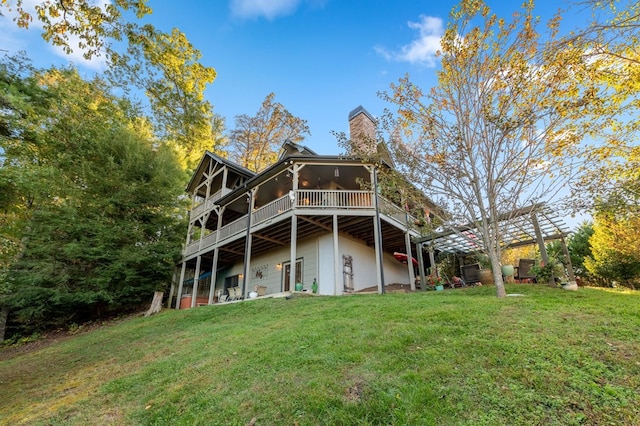 back of property featuring a pergola, a lawn, and a wooden deck