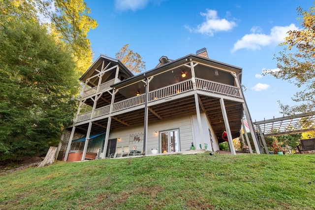 rear view of house with a pergola and a lawn