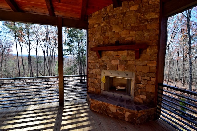 wooden terrace featuring an outdoor stone fireplace