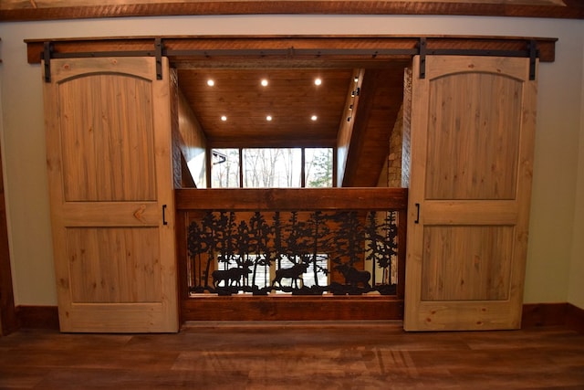 room details featuring a barn door and wood-type flooring