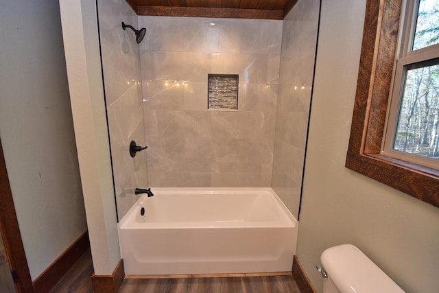 bathroom with toilet, tiled shower / bath, and hardwood / wood-style flooring