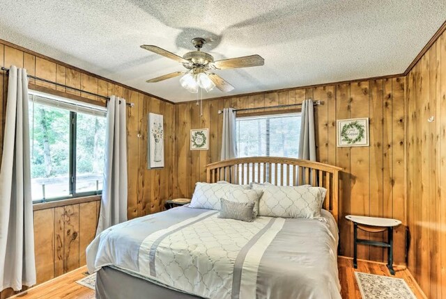 34 Clover Ln, Murphy, NC 28906 - bedroom featuring wooden walls, wood finished floors, a textured ceiling, and a ceiling fan