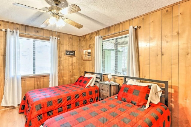 34 Clover Ln, Murphy, NC 28906 - bedroom with a textured ceiling, wood walls, wood finished floors, ceiling fan, and ornamental molding