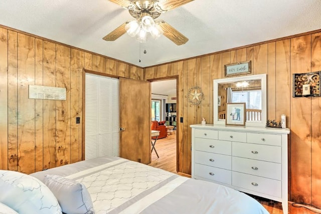 34 Clover Ln, Murphy, NC 28906 - bedroom with light wood finished floors, wood walls, a closet, ornamental molding, and ceiling fan