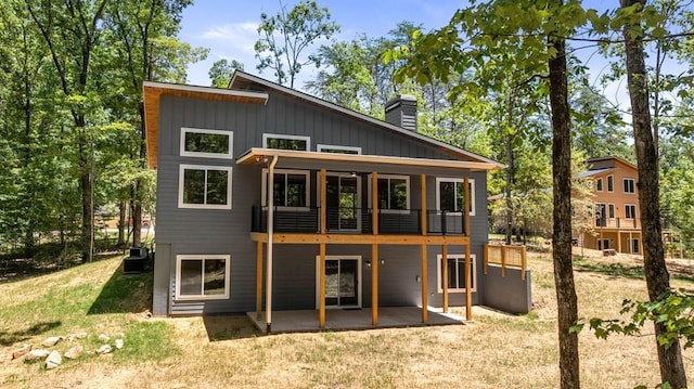 back of property with a lawn, a patio area, and cooling unit