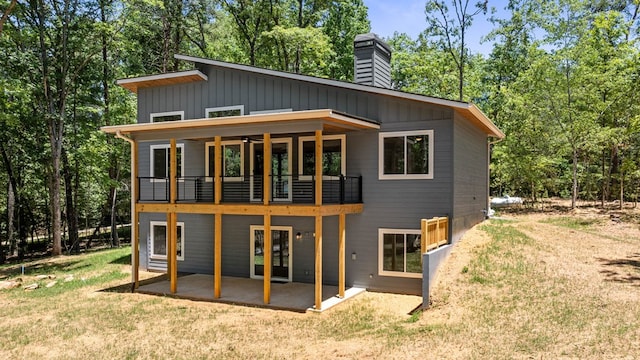 rear view of property featuring a lawn and a patio area