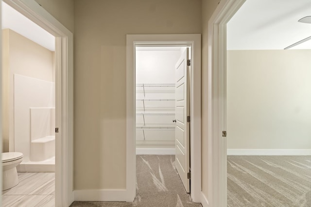 corridor featuring light colored carpet