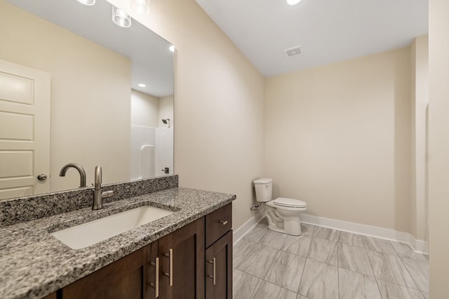 bathroom featuring a shower, vanity, and toilet