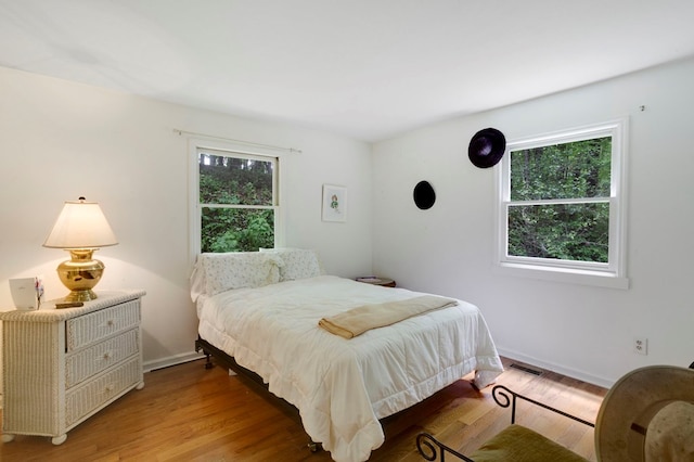 249 Chatuge Woods Dr, Hayesville, NC 28904 - bedroom with multiple windows, light wood-style flooring, and baseboards