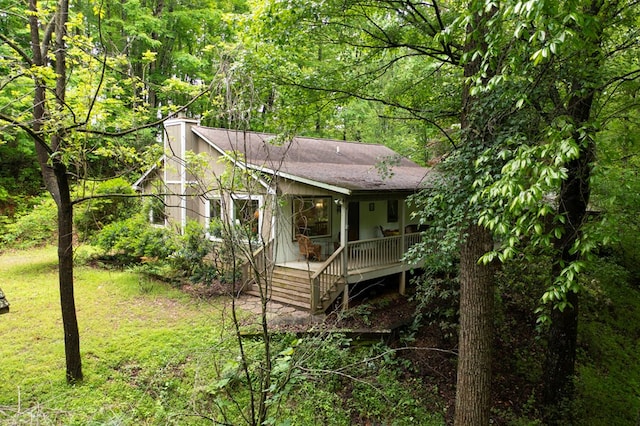 249 Chatuge Woods Dr, Hayesville, NC 28904 - view of front of home with a chimney, a front yard, roof with shingles, and a view of trees