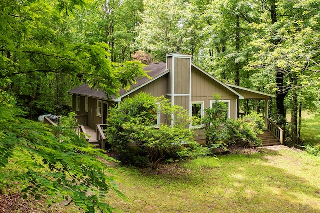 249 Chatuge Woods Dr, Hayesville, NC 28904 - view of side of home featuring a chimney, a wooded view, a deck, and a yard