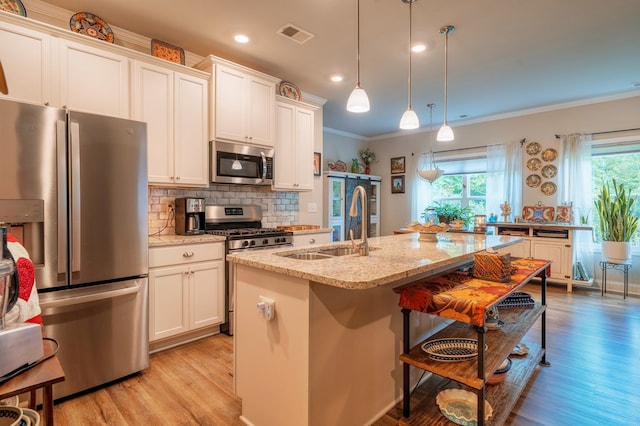 56 Highland Pointe Dr, Ellijay, GA 30536 - kitchen with appliances with stainless steel finishes, ornamental molding, light wood-style floors, backsplash, and a center island with sink