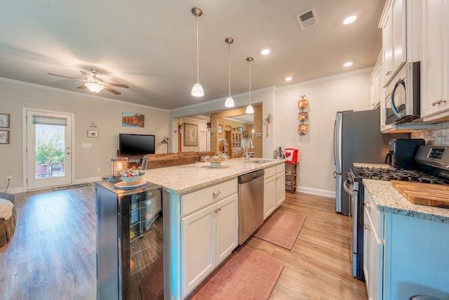 56 Highland Pointe Dr, Ellijay, GA 30536 - kitchen featuring stainless steel appliances, open floor plan, an island with sink, wine cooler, and white cabinetry