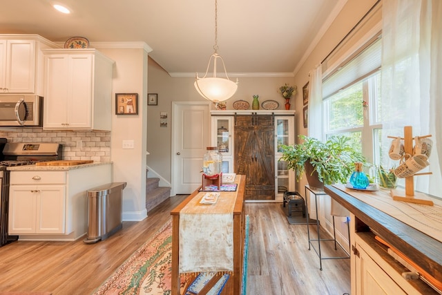56 Highland Pointe Dr, Ellijay, GA 30536 - kitchen with stainless steel appliances, crown molding, decorative backsplash, white cabinets, and light wood-style floors