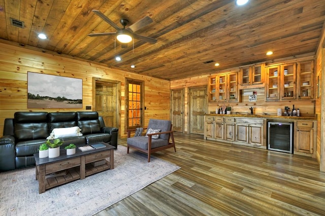 living area featuring dark wood-style flooring, wine cooler, a ceiling fan, indoor wet bar, and wooden ceiling
