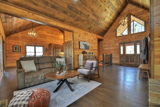 living area featuring high vaulted ceiling, wooden walls, a notable chandelier, and plenty of natural light