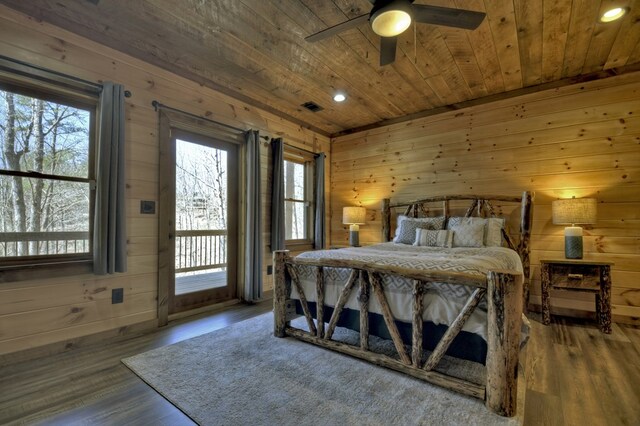 bedroom featuring access to exterior, wooden ceiling, wood finished floors, wood walls, and visible vents