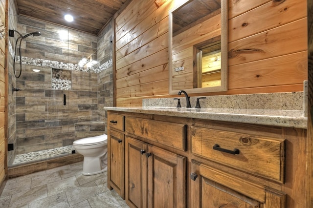 full bathroom featuring a stall shower, wooden walls, toilet, and vanity