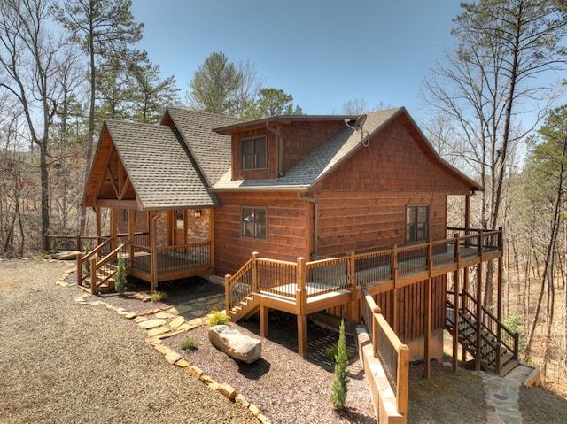 back of property with stairs, a shingled roof, and a wooden deck