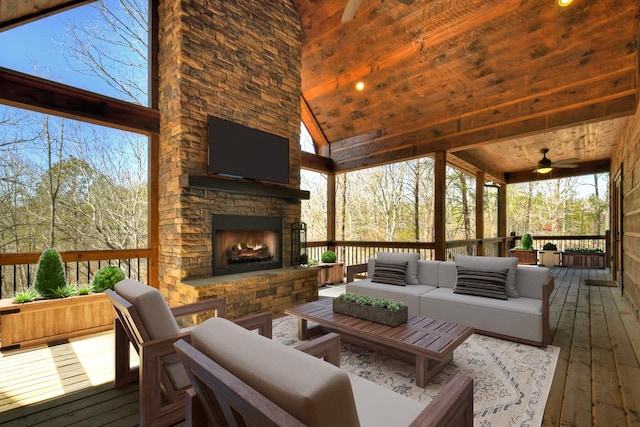 deck with a ceiling fan and an outdoor living space with a fireplace
