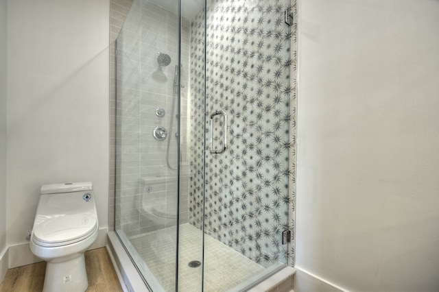 bathroom featuring wood-type flooring, toilet, and walk in shower