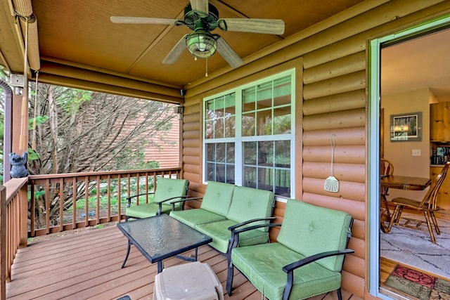 wooden terrace with an outdoor living space and a ceiling fan