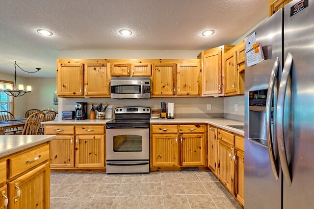 kitchen featuring recessed lighting, light countertops, a textured ceiling, and appliances with stainless steel finishes