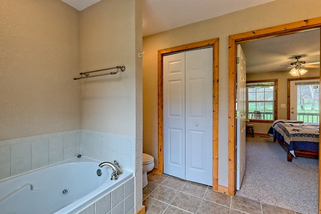 full bathroom with toilet, a closet, ceiling fan, and a tub with jets