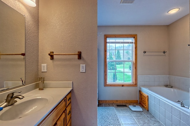 bathroom with vanity, baseboards, tile patterned floors, a bath, and visible vents