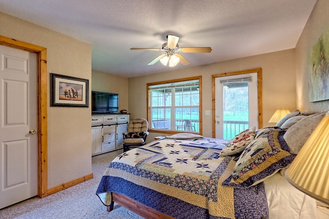 carpeted bedroom featuring access to outside, baseboards, and a ceiling fan