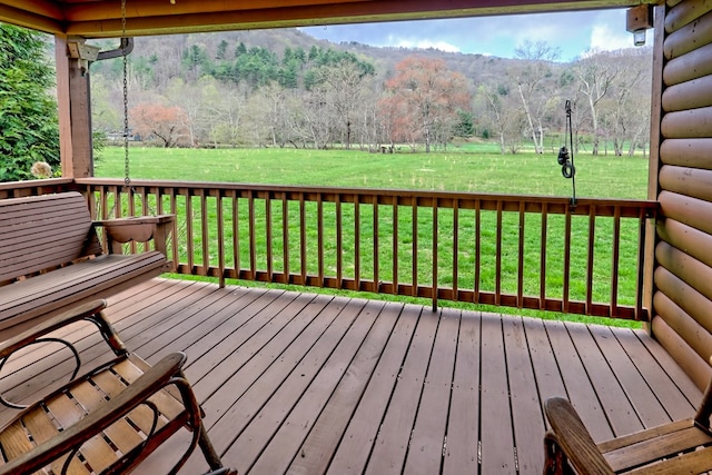 wooden deck with a yard and a view of trees