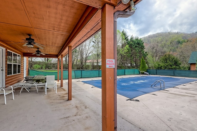 pool featuring a mountain view, a patio, ceiling fan, and fence