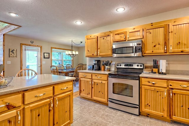 kitchen featuring light countertops, a textured ceiling, and stainless steel appliances
