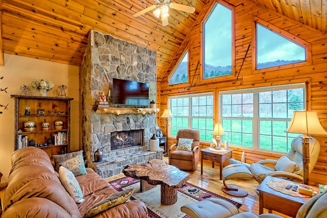 living room featuring wooden ceiling, a stone fireplace, a ceiling fan, wood-type flooring, and high vaulted ceiling