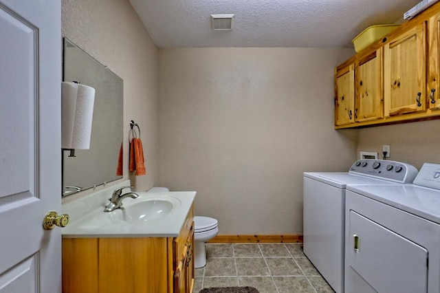 laundry room featuring baseboards, washing machine and dryer, visible vents, laundry area, and a sink