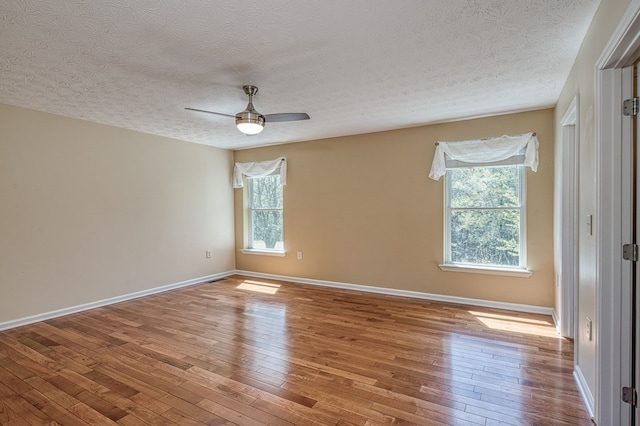 spare room featuring hardwood / wood-style flooring, a textured ceiling, and ceiling fan