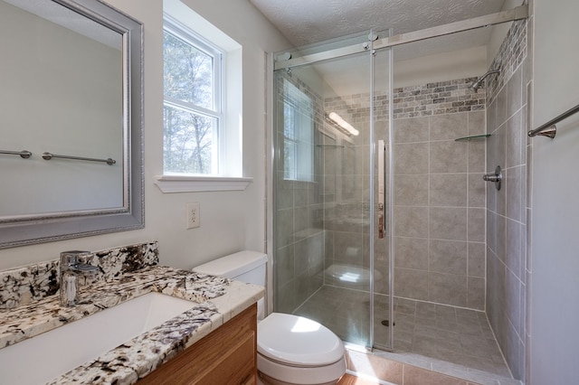full bathroom featuring toilet, vanity, and a shower stall