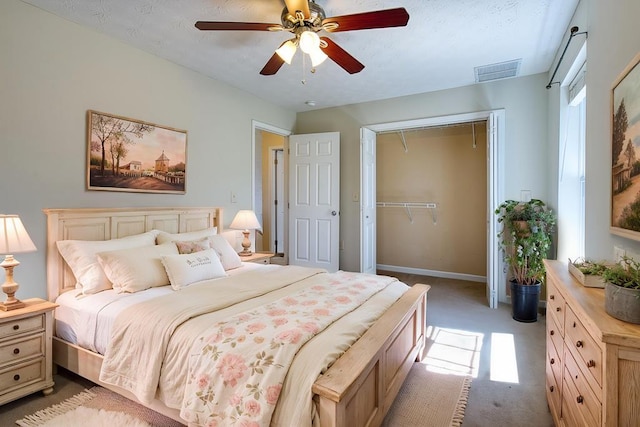 bedroom with visible vents, a closet, ceiling fan, attic access, and light colored carpet