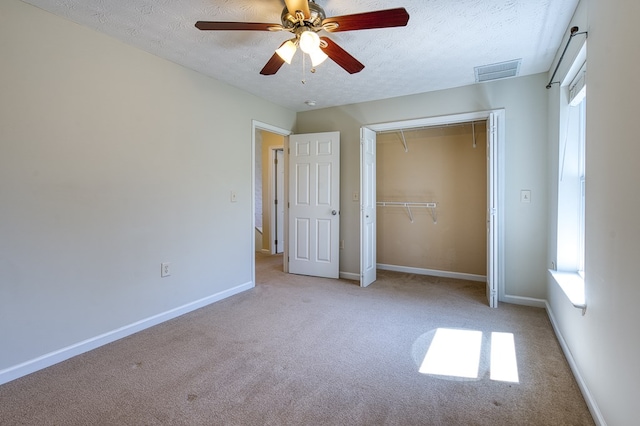 unfurnished bedroom with visible vents, baseboards, carpet, a textured ceiling, and attic access