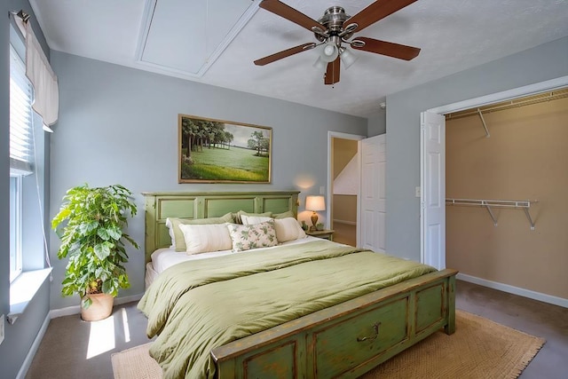 bedroom featuring a closet, baseboards, attic access, and a ceiling fan