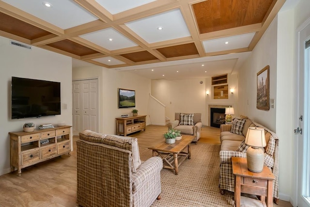 living room featuring baseboards, a fireplace, visible vents, beamed ceiling, and coffered ceiling