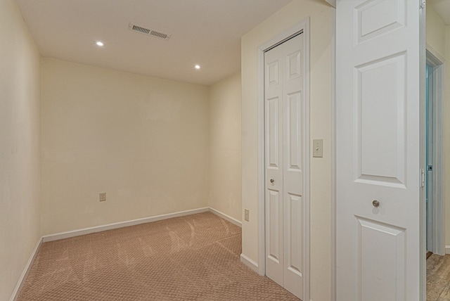 hallway with light carpet, recessed lighting, visible vents, and baseboards