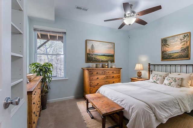carpeted bedroom featuring visible vents, baseboards, multiple windows, and ceiling fan