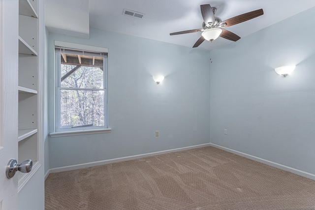 carpeted empty room featuring visible vents, baseboards, and a ceiling fan