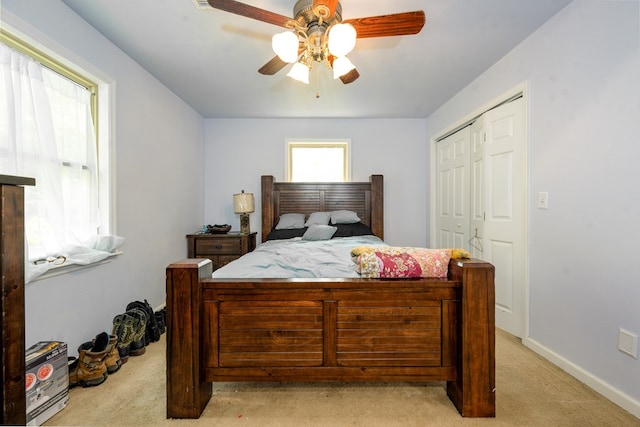 bedroom with ceiling fan, a closet, and light carpet