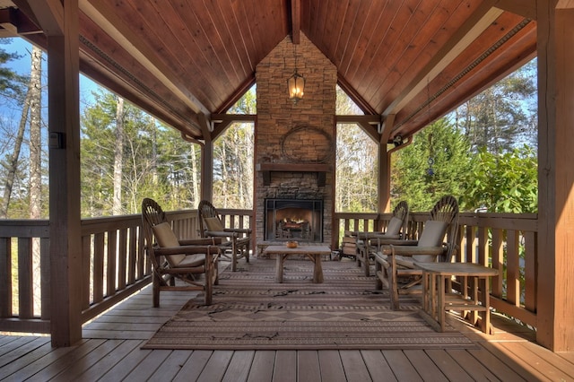 wooden terrace with an outdoor stone fireplace