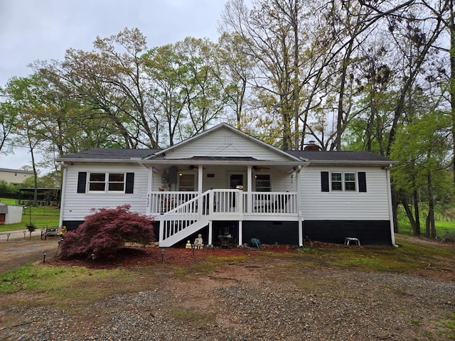 view of front of house with a chimney, a ceiling fan, and covered porch