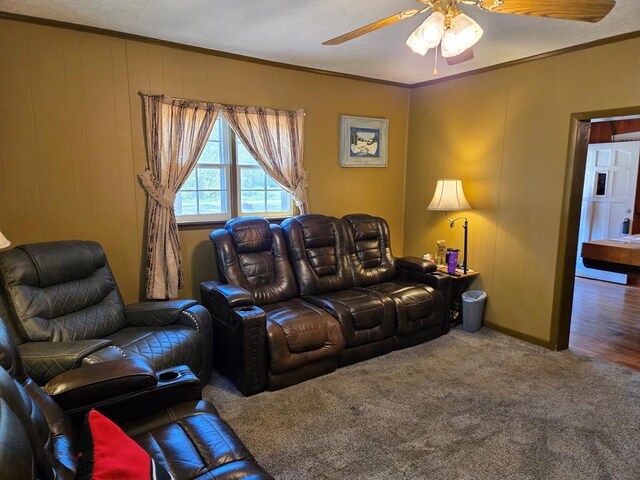 living area with ornamental molding, a ceiling fan, and carpet